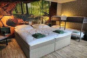 A bedroom with a large bed, a bunk bed, a desk, and a chair. - Kriemhild's Dragon's Cave (Xanten)