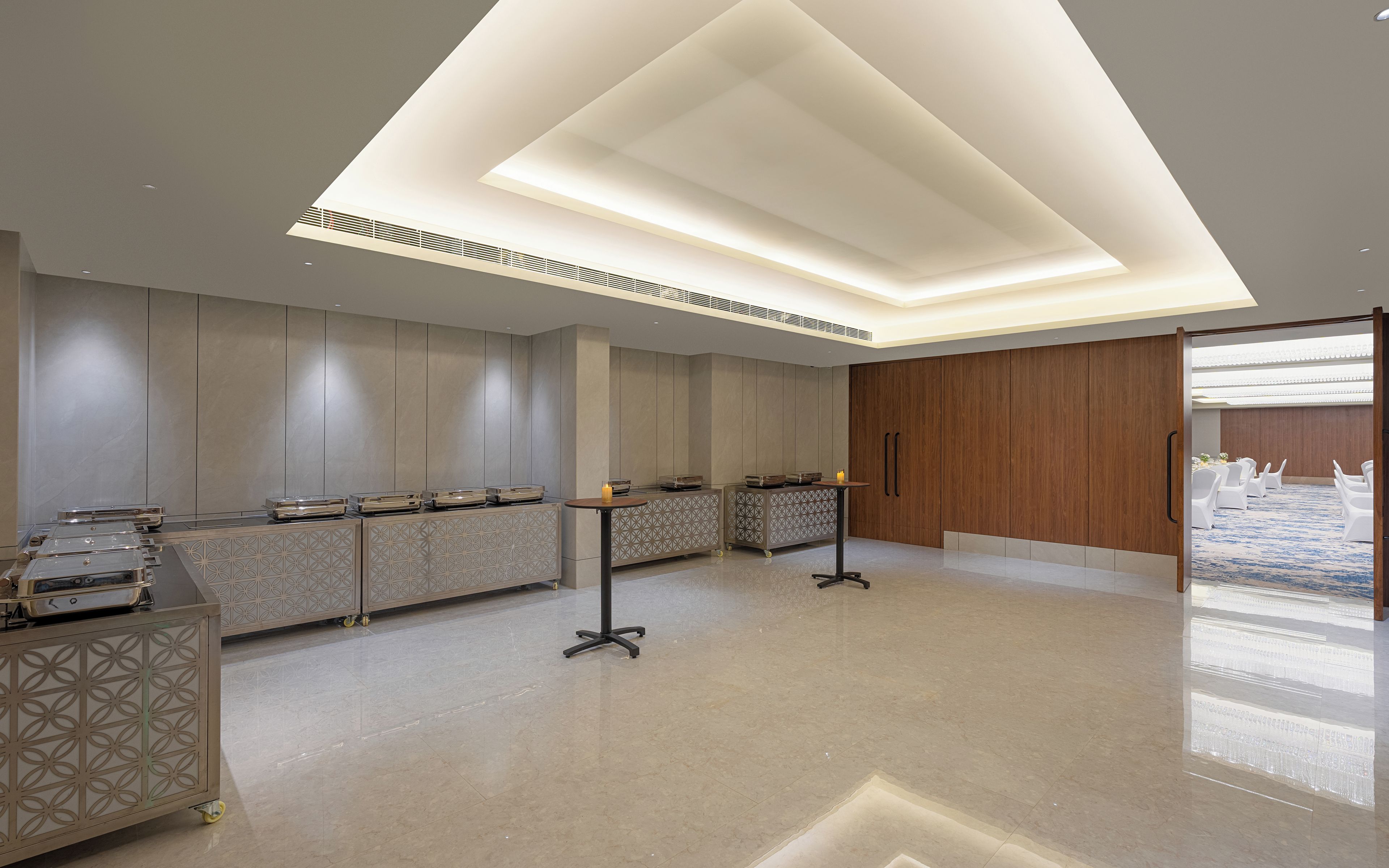 Un hall d’hôtel moderne avec un comptoir d’accueil, un espace salon et une vue sur la cour intérieure.