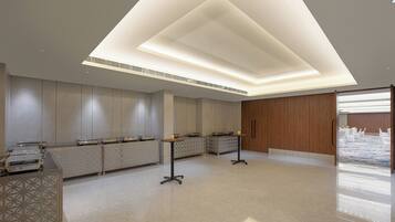 Un hall d’hôtel moderne avec un comptoir d’accueil, un espace salon et une vue sur la cour intérieure.