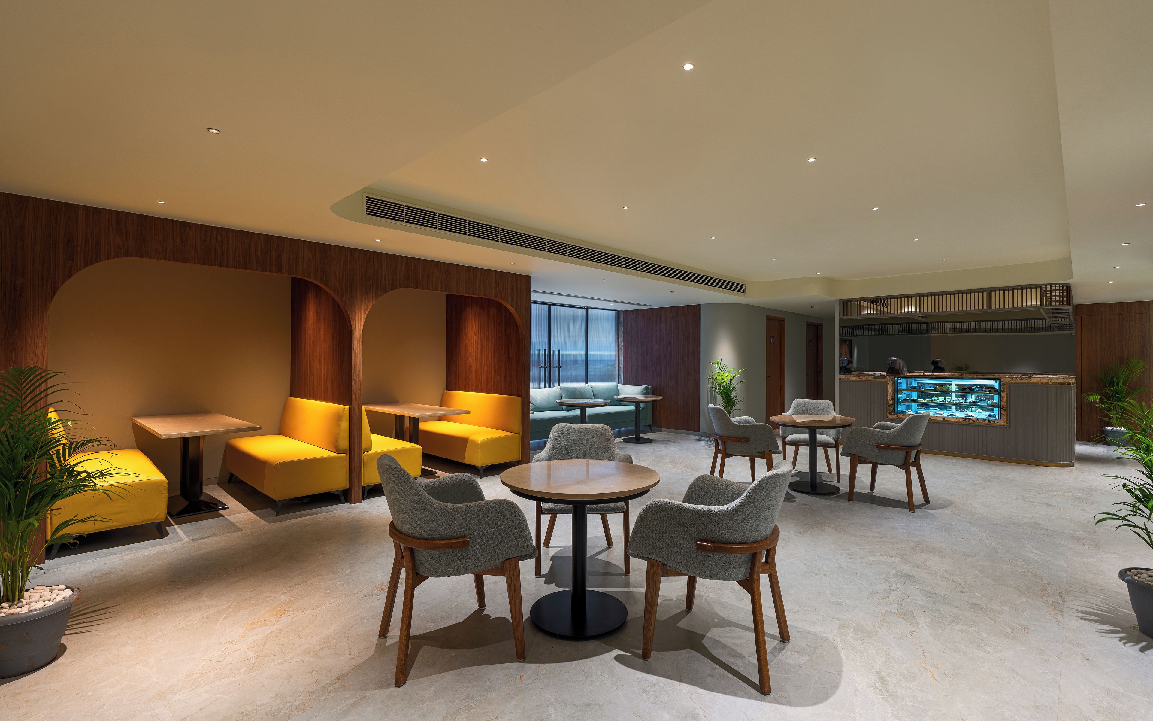 Un moderno espacio lounge con asientos, un bar y vistas al exterior.