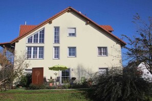 A two-story building with a red-tiled roof, multiple windows, and a front door. - Holiday apartment with 2 bedrooms (Mühlhausen-Ehingen)