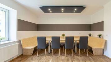 A conference room with a long table, six chairs, and a ceiling light fixture.