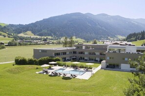 A modern hotel with a swimming pool and a view of mountains. - Apartment in Radstadt with swimming pool (Radstadt)