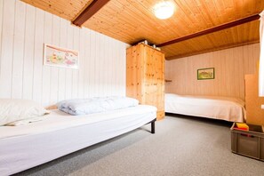 A room with two beds, wooden walls, and a ceiling light. - Nydamsgaard "hus mælkebøtte" (Faaborg \/ Bojden)