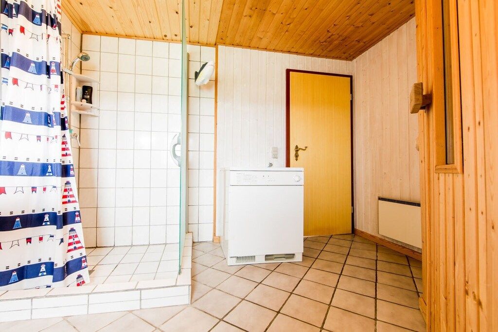 Une salle de bain avec une douche, des toilettes et un radiateur blanc.