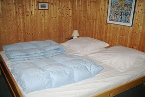 Ein Bett mit vielen Kissen und einem hölzernen Kopfteil.