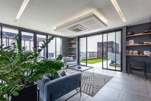 Un salon moderne avec un canapé, une table basse et des plantes en pot.