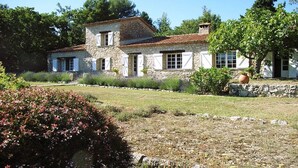 A stone house with a tiled roof, surrounded by a well-maintained garden and trees. - La Bergerie de l'Aspe (Saint Cézaire\/Siagne)