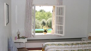 A bedroom with a bed, a desk with a lamp, and a window with curtains. - La Bergerie de l'Aspe (Saint Cézaire\/Siagne)