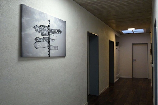 Un couloir avec un panneau indicateur sur le mur et une porte au fond.