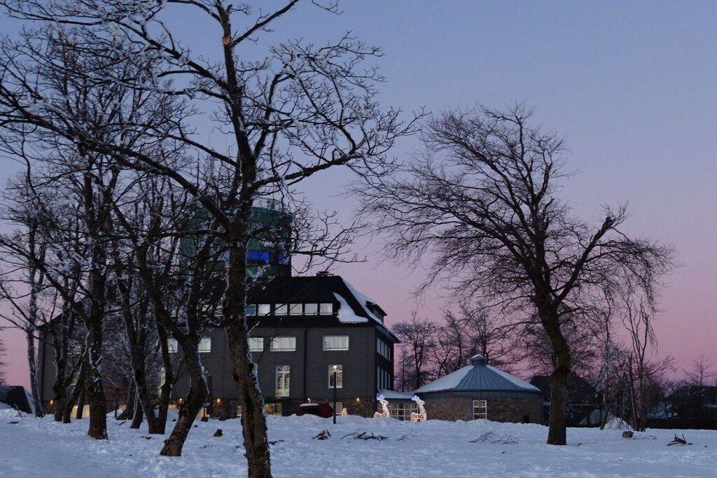 A building with multiple windows and a snow-covered ground.