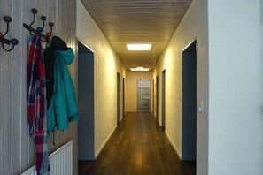 A hallway with a wooden floor and a coat rack on the left. - City view Winterberg (Winterberg)