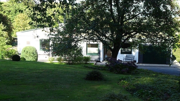 A house with a well-maintained lawn, a tree, and a bench. - Henriette's holiday home (Bad Harzburg)