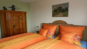A bedroom with a bed, a wooden wardrobe, and a painting on the wall. - Henriette's holiday home (Bad Harzburg)