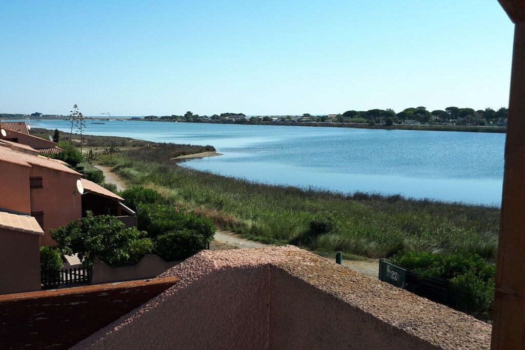 Une vue sur une rivière, avec un bâtiment sur la gauche et un ciel dégagé.