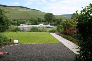 A river with a boat, a grassy area, and a pathway. - "Abundance" on the banks of the Moselle (Bernkastel-Kues\/Andel)