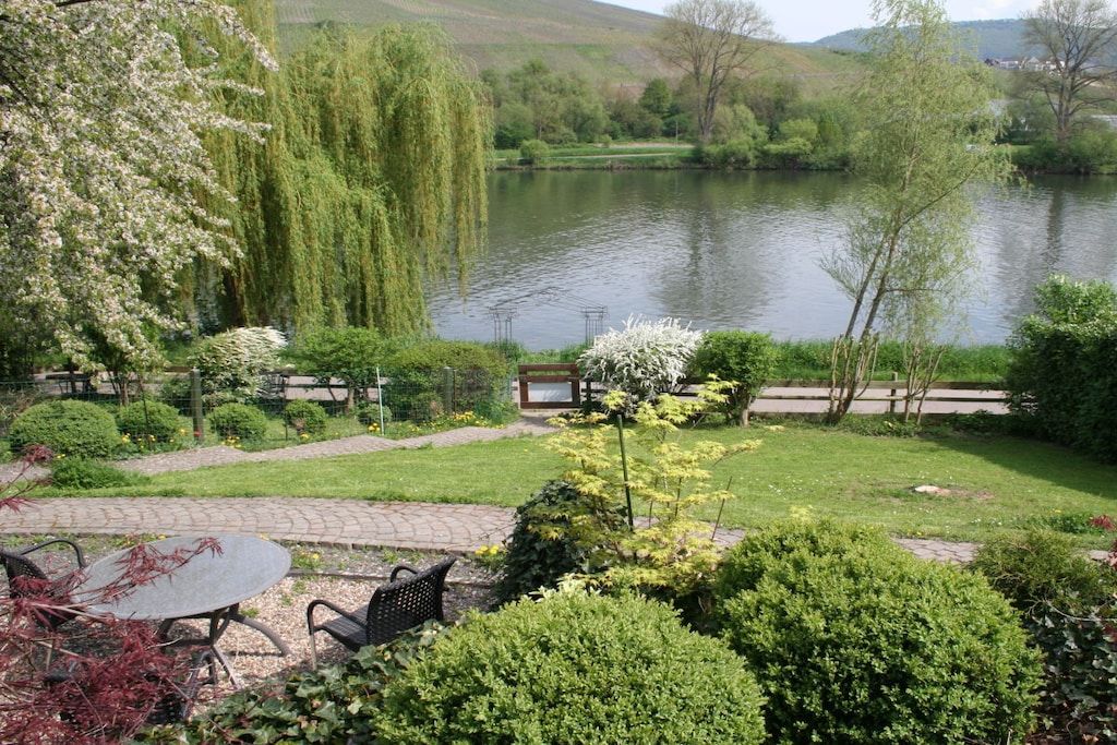 Ein Garten mit Teich, einem Tisch mit Stühlen und einer Bank.