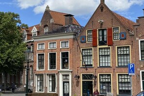 A row of traditional brick buildings with uniform window designs and a clear blue sky. - Holiday cottage "Jantje" (Bunde)
