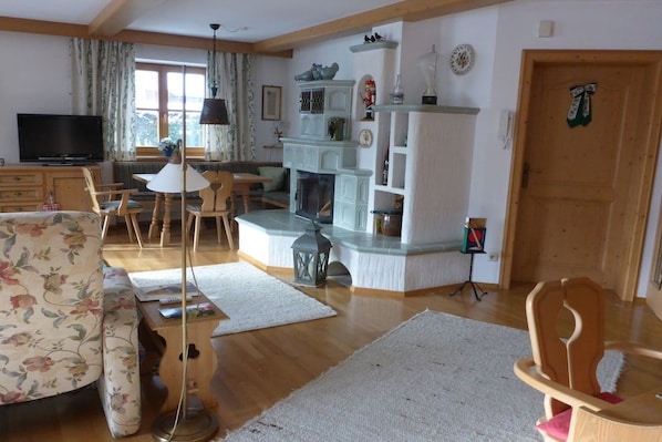 A living room with a fireplace, wooden furniture, and a television. - Holiday apartment with 1 bedroom (Aschau\/Chiemgau)