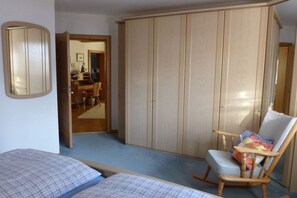 A bedroom with two beds, a rocking chair, and a wardrobe. - Holiday apartment with 1 bedroom (Aschau\/Chiemgau)
