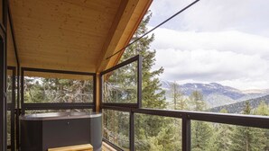 A wooden deck with a hot tub and a view of a forested mountain range. - Superior Chalet #16 With Sauna & Hot Tub (Stadl-Predlitz)