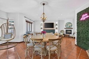 A dining area with a round table, chairs, and a hanging light fixture. - Lagosta Beach House (Gafanha da Boa Hora)