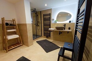 A modern bathroom with a wooden shelf, a large mirror, and a black towel rack. - Bergstadthaus Sankt Andreasberg (St. Andreasberg)