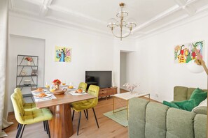 A modern living room with a dining area, a television, and artwork on the walls. - Charming 2BR in Saint-Germain-des-Pres (Paris)