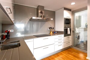 A modern kitchen with stainless steel appliances, white cabinetry, and a built-in oven. - Beautiful Marilyn, 4th Floor, Marina Botafoch, Ibiza (Eivissa)