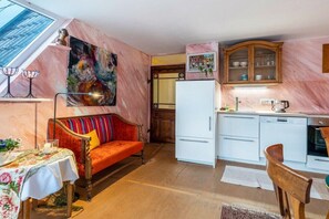 Una cocina acogedora con comedor, un sofá y un cuadro grande.