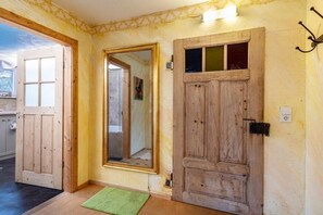 A room with a wooden door, a large mirror, and a green mat on the floor. - Holiday apartment House of the Painters' Cloud Two (Müllheim)