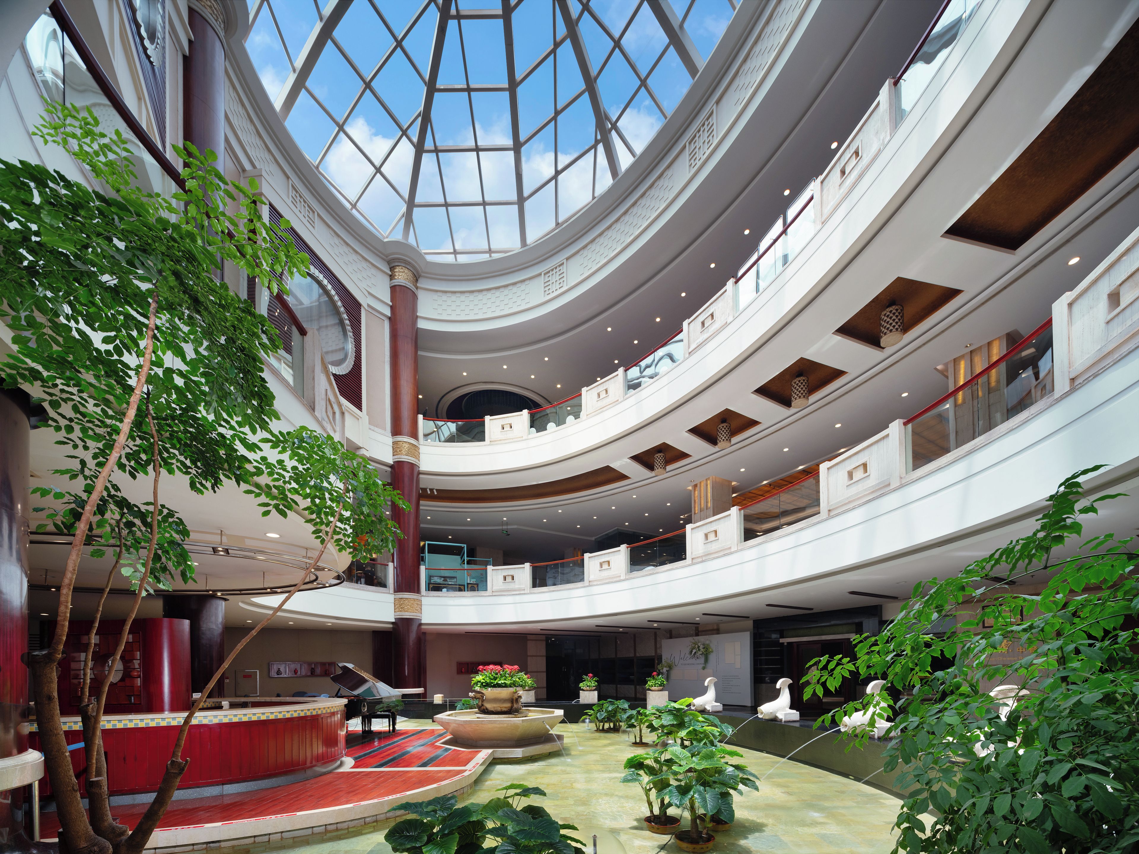 A multi-level atrium with a central open space, multiple floors, and a glass ceiling allowing natural light.