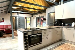 A modern kitchen with a central island, built-in oven, and a coffee maker. - Holiday home Wendland hideaway (Gartow)