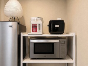 A kitchen area with a Haier refrigerator, a coffee maker, and a microwave on a white shelf. - SOL Guesthouse Konohana (Osaka)