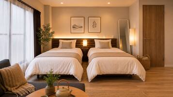 A hotel room with two beds, a sitting area with a table, and a large mirror.