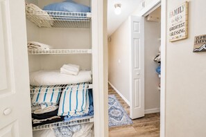 Een kamer met een stapelbed, een deur die naar een andere kamer leidt, en een muur met inspirerende citaten.