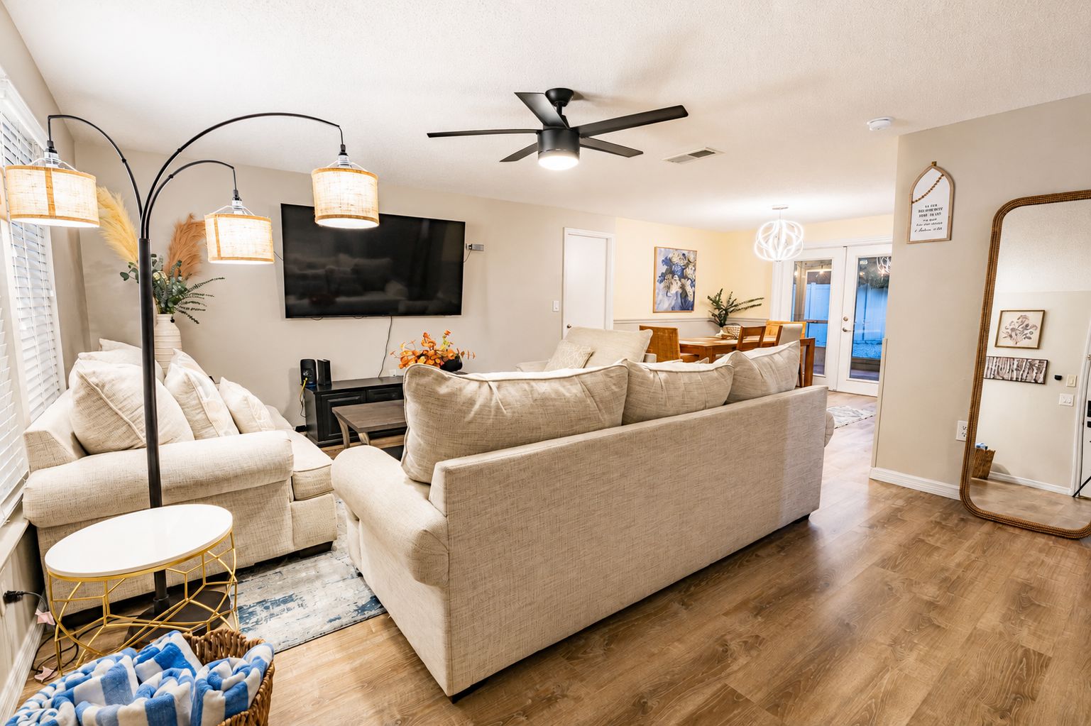 A living room with a sofa, a coffee table, a TV, and a ceiling fan.