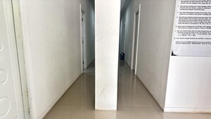 A corridor with a tiled floor leading to a door at the end. - Relaxing Stay at Medina House (Banda Aceh)