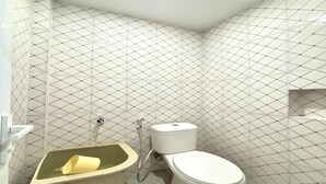 A bathroom with a toilet, a sink, and a bathtub. - Relaxing Stay at Medina House (Banda Aceh)
