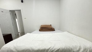 A room with a bed, a door, and a wall. - Relaxing Stay at Medina House (Banda Aceh)