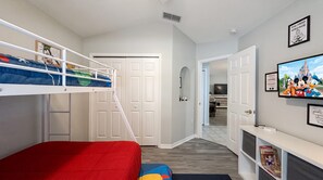 A child's bedroom with bunk beds, a TV, and Disney-themed decorations. - Starlight and Shells Pool (Davenport)