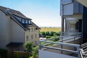 A residential building with a balcony overlooking a grassy field. - Holiday apartment in Büsum with swimming pool (Büsum)