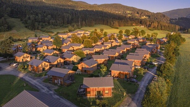 Zona residencial con varias casas, caminos y un paisaje montañoso al fondo.