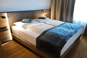 Ein Hotelzimmer mit Bett, Nachttisch und Kopfteil.