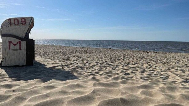 En strand med en stol, der er mærket '109' og 'M'.