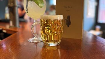 Een bar setting met een glazen mok en een cocktail op een houten ondergrond.