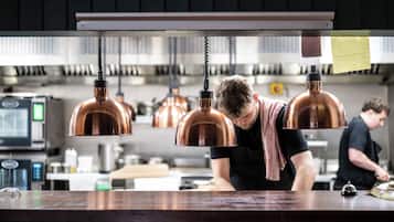 A kitchen with copper pendant lights, a wooden countertop, and a person working at the counter.