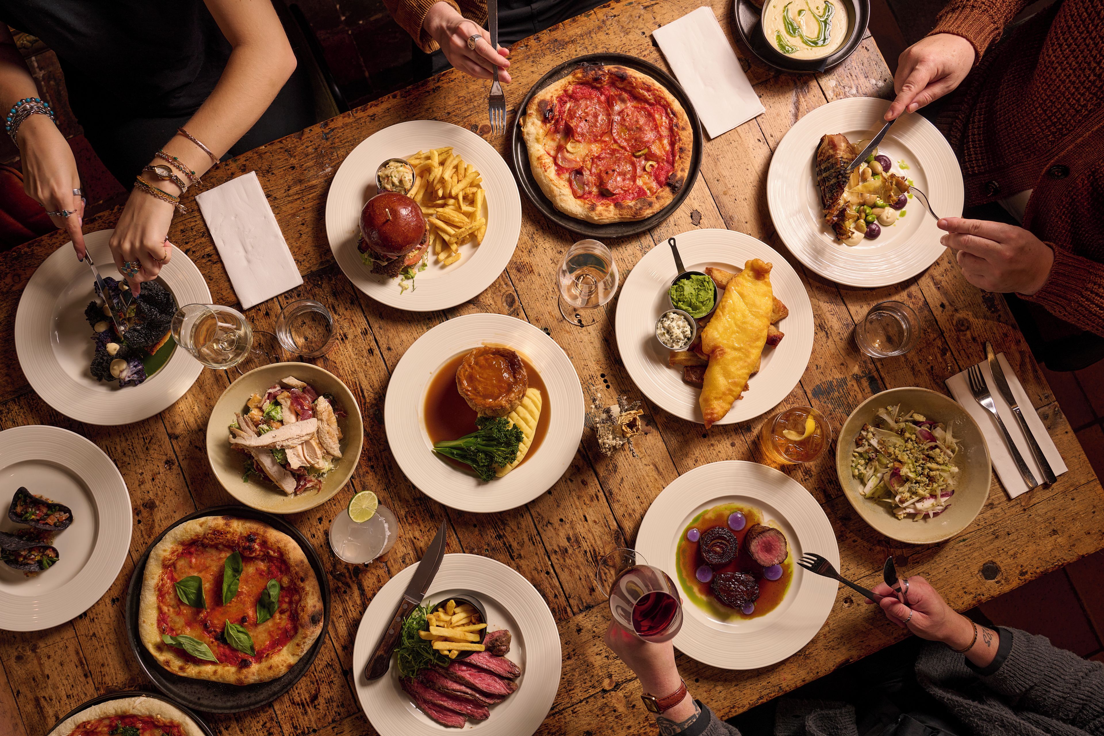 A dining table with various dishes and people dining.