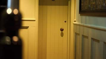 A hallway with a closed door marked with the number 1, a carpeted floor, and a painting on the wall.