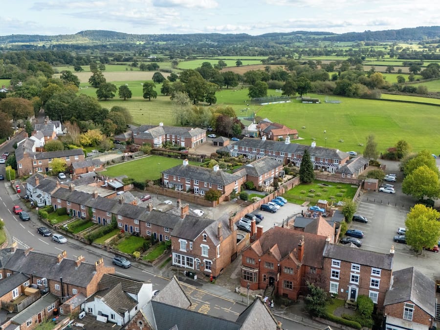 A residential area with houses, a road, and a green field.